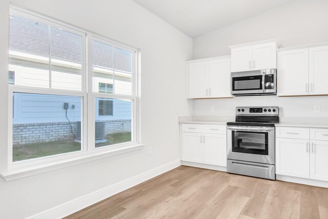 kitchen with white cabinetry, light hardwood / wood-style floors, appliances with stainless steel finishes, and a wealth of natural light