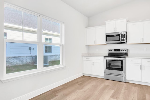 601 Alleyoak Ln Lot 11-2, Freeport, FL 32439 - kitchen featuring appliances with stainless steel finishes, lofted ceiling, light wood finished floors, white cabinets, and light countertops