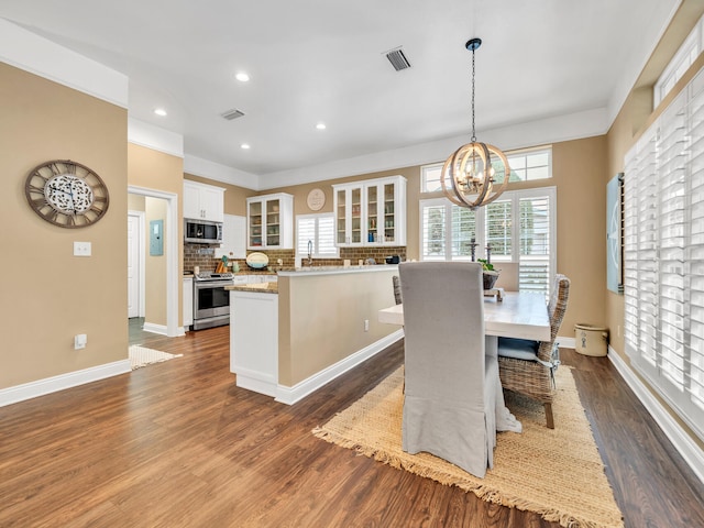 dining space with a chandelier, wood-type flooring, and sink