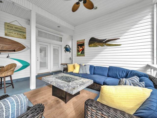 interior space featuring ceiling fan and an outdoor living space with a fire pit