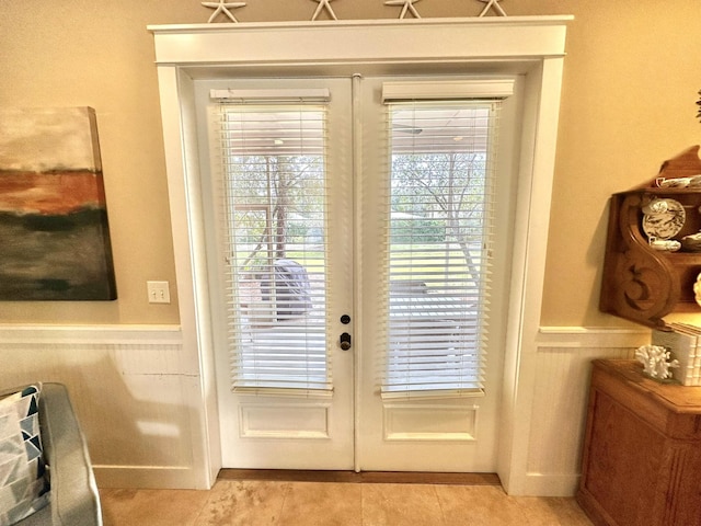 2450 Bungalo Ln, Miramar Beach, FL 32550 - doorway to outside with a wainscoted wall, french doors, and light tile patterned floors