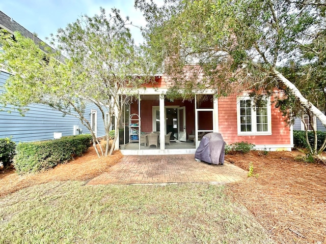 rear view of property featuring a yard and a patio area