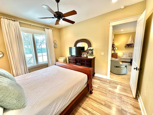 bedroom featuring ornamental molding, ceiling fan, and light hardwood / wood-style floors