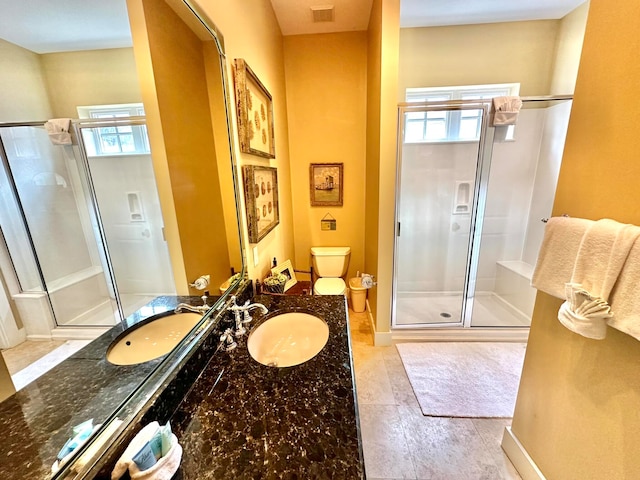 bathroom featuring a wealth of natural light, a shower with door, vanity, and tile patterned flooring