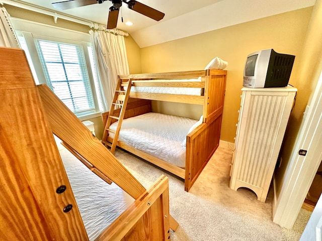 carpeted bedroom featuring ceiling fan and vaulted ceiling