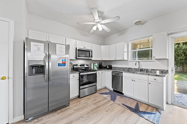 kitchen featuring appliances with stainless steel finishes, white cabinets, and light wood-type flooring