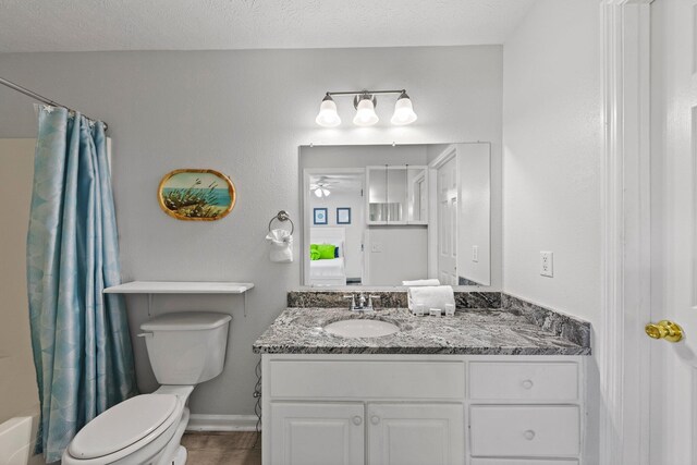 full bathroom with ceiling fan, a textured ceiling, wood-type flooring, toilet, and vanity