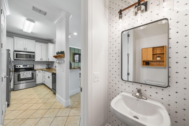 bathroom featuring tile patterned flooring, ornamental molding, sink, and tasteful backsplash