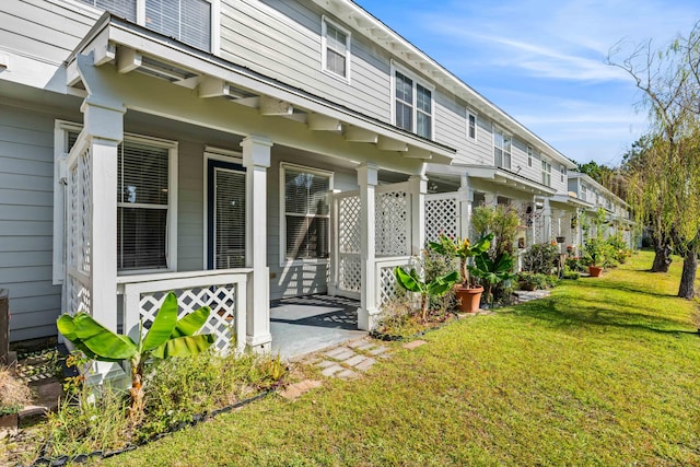 rear view of house featuring a porch, a wall unit AC, and a lawn