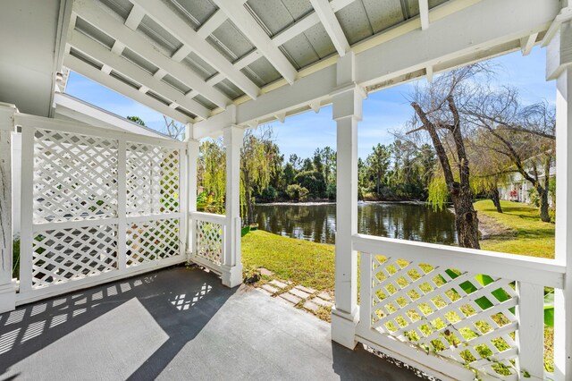 sunroom with lofted ceiling with beams, a water view, and plenty of natural light