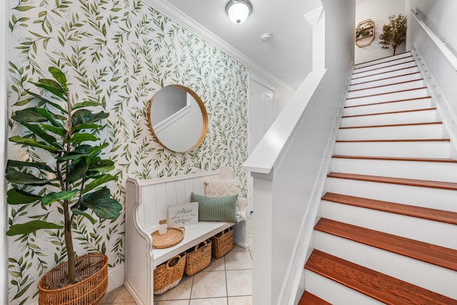 staircase with tile patterned floors and ornamental molding