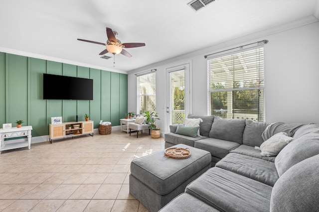 tiled living room featuring ceiling fan and ornamental molding