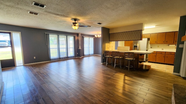 kitchen with a kitchen breakfast bar, a healthy amount of sunlight, and dark wood-type flooring