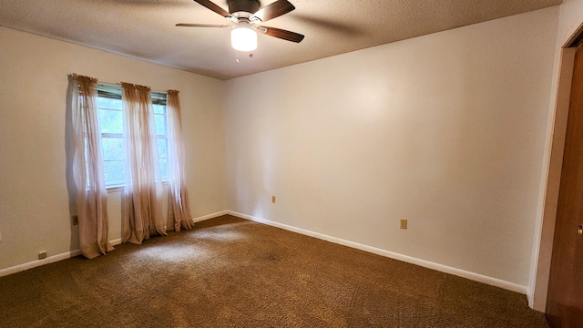 empty room featuring a textured ceiling, ceiling fan, and dark colored carpet