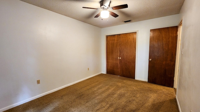 unfurnished bedroom featuring a textured ceiling, carpet flooring, a closet, and ceiling fan