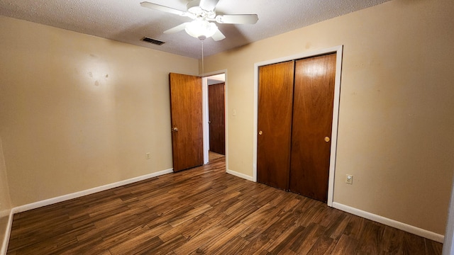 unfurnished bedroom featuring a textured ceiling, dark hardwood / wood-style floors, a closet, and ceiling fan