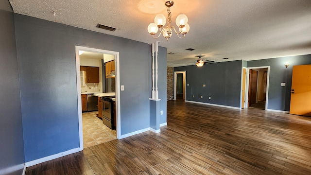 unfurnished room featuring a textured ceiling, ceiling fan with notable chandelier, and light hardwood / wood-style floors