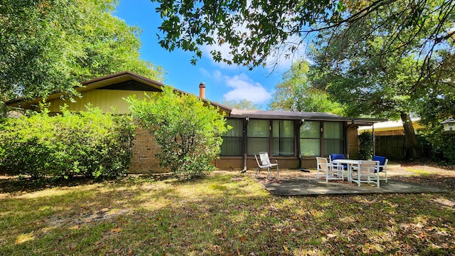 back of house with a yard, a patio area, and a sunroom