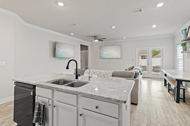 kitchen featuring crown molding, sink, light hardwood / wood-style floors, and a center island with sink