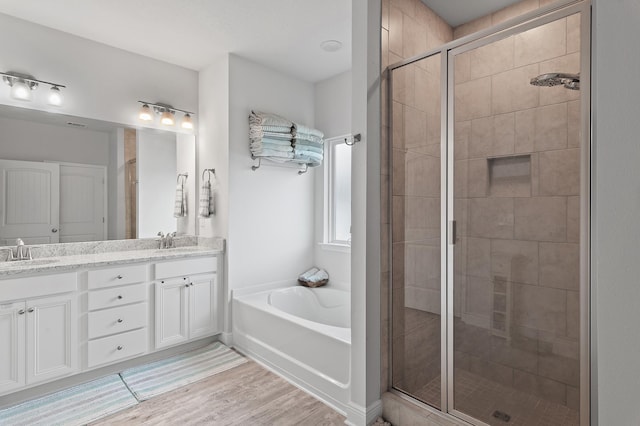 bathroom with vanity, independent shower and bath, and hardwood / wood-style flooring