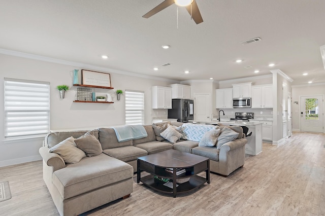 living room with ceiling fan, sink, light hardwood / wood-style floors, and ornamental molding