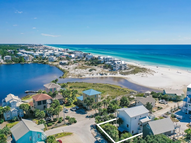 drone / aerial view with a water view and a beach view