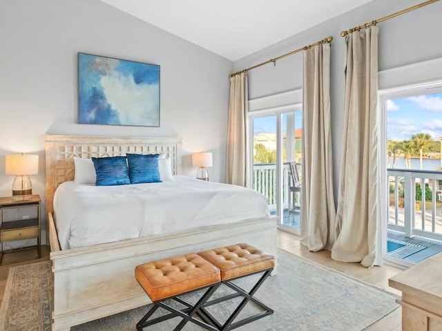 bedroom featuring light hardwood / wood-style flooring, lofted ceiling, and access to exterior