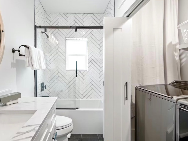 full bathroom featuring toilet, tile patterned floors, vanity, tiled shower / bath combo, and washer and clothes dryer