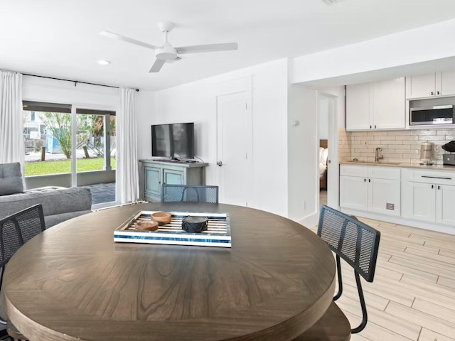 dining area with ceiling fan, sink, and light hardwood / wood-style floors