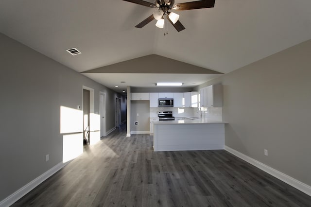 kitchen with vaulted ceiling, white cabinetry, backsplash, kitchen peninsula, and stainless steel appliances