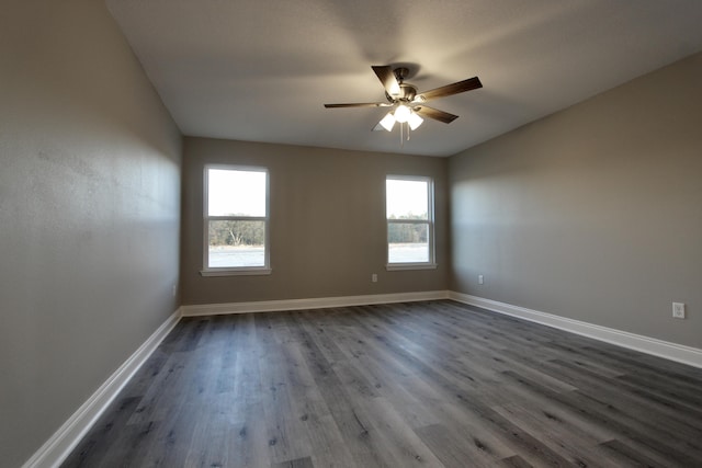 spare room featuring ceiling fan, dark hardwood / wood-style floors, and a wealth of natural light