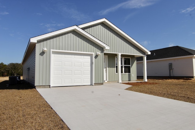 view of front of home featuring concrete driveway, an attached garage, board and batten siding, and central AC