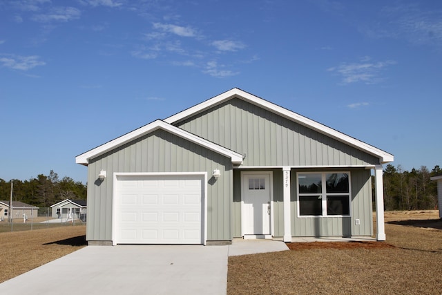 view of front facade with driveway, board and batten siding, and an attached garage