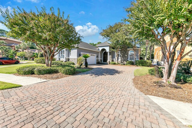 4705 Seastar Vis, Destin, FL 32541 - view of front of house with decorative driveway, an attached garage, stone siding, and stucco siding