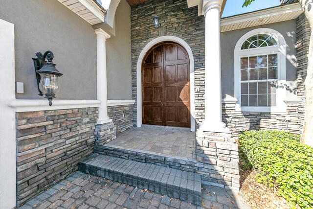 4705 Seastar Vis, Destin, FL 32541 - view of exterior entry with a porch, stone siding, and stucco siding