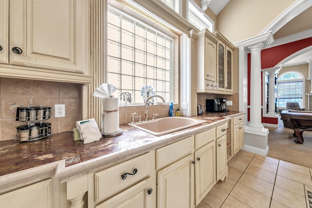 4705 Seastar Vis, Destin, FL 32541 - kitchen with ornate columns, arched walkways, cream cabinets, a sink, and light tile patterned floors