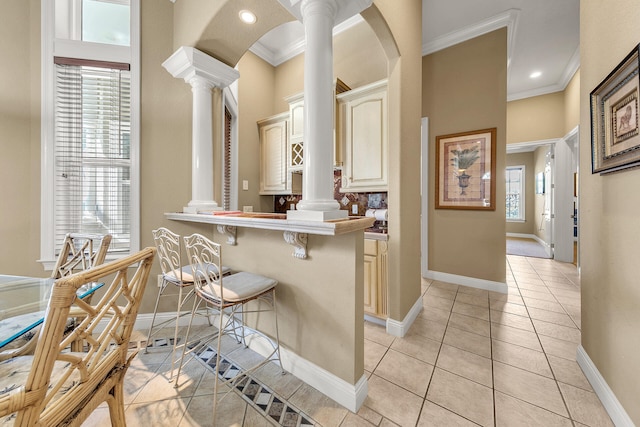 4705 Seastar Vis, Destin, FL 32541 - kitchen with crown molding, ornate columns, a breakfast bar, and cream cabinetry
