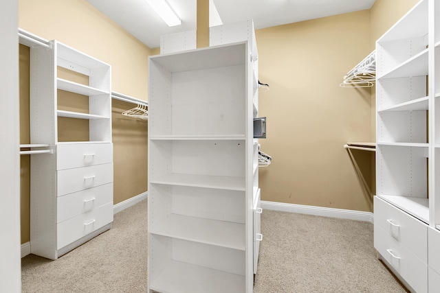 walk in closet featuring light carpet