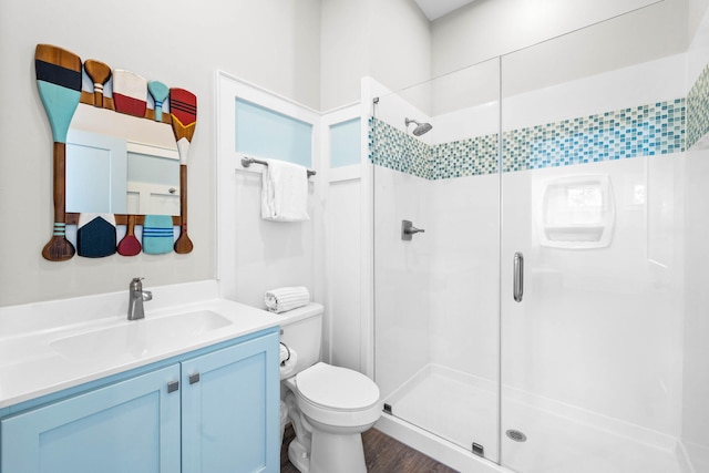 bathroom featuring vanity, toilet, walk in shower, and wood-type flooring