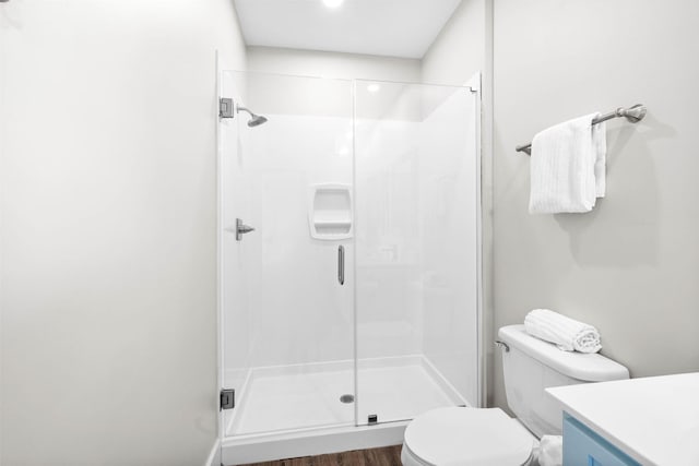 bathroom featuring toilet, an enclosed shower, hardwood / wood-style floors, and vanity