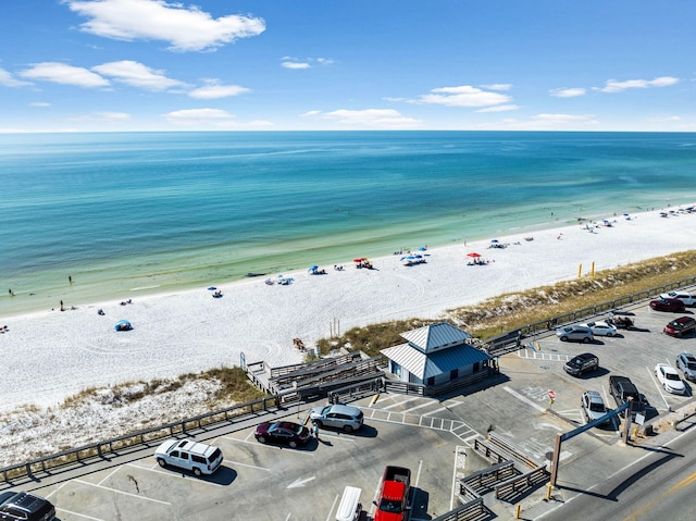 drone / aerial view with a water view and a beach view