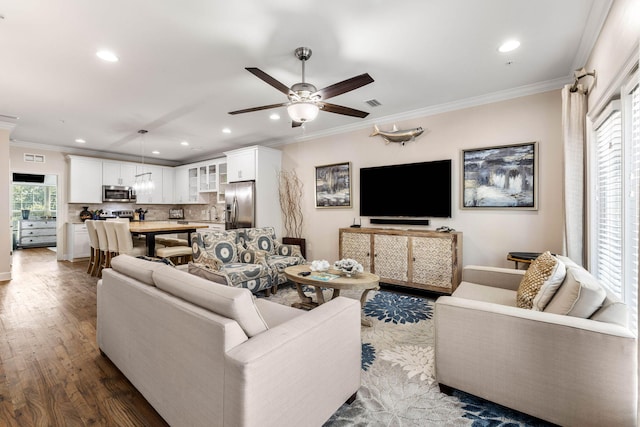 living room featuring ceiling fan, hardwood / wood-style flooring, sink, and crown molding