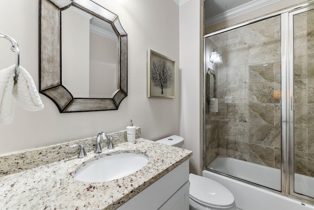 full bathroom featuring vanity, combined bath / shower with glass door, ornamental molding, and toilet