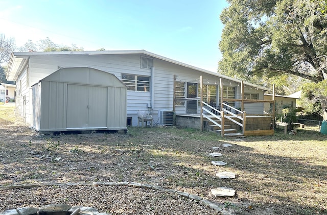 rear view of house featuring a storage unit and central air condition unit