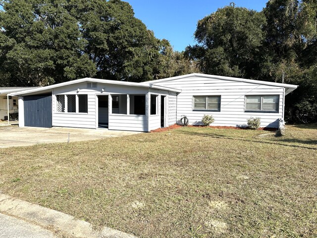 single story home featuring a front yard and a carport