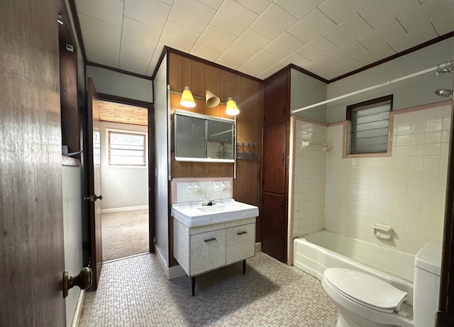 full bathroom featuring vanity, tile patterned floors, tiled shower / bath, crown molding, and toilet