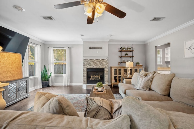 living room featuring ornamental molding, ceiling fan, a fireplace, and dark hardwood / wood-style flooring