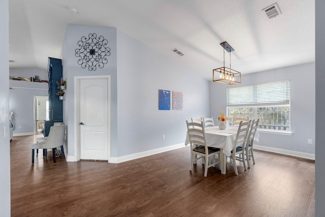 dining area with dark hardwood / wood-style floors and vaulted ceiling