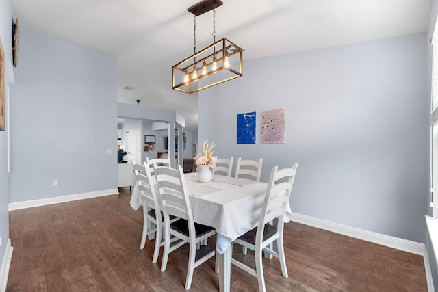 dining space with a notable chandelier and dark hardwood / wood-style floors