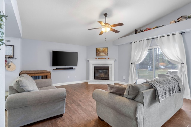 living room featuring dark wood-type flooring, vaulted ceiling, and ceiling fan